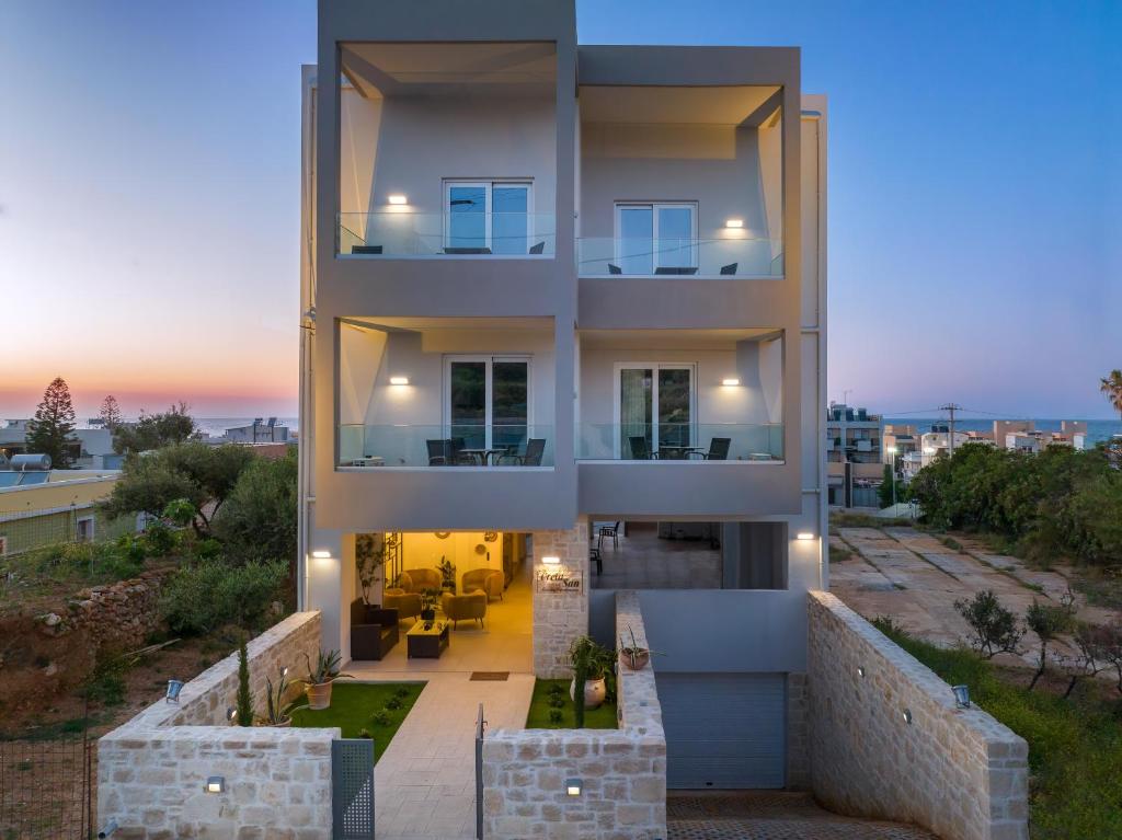 un grand bâtiment avec un coucher de soleil en arrière-plan dans l'établissement Creta Sun luxury apartments, à Réthymnon