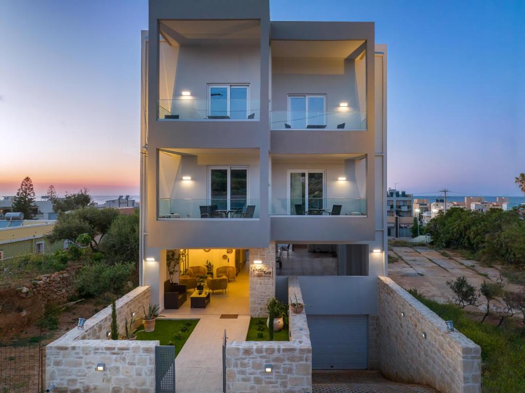 ein großes Gebäude mit Sonnenuntergang im Hintergrund in der Unterkunft Creta Sun luxury apartments in Rethymno