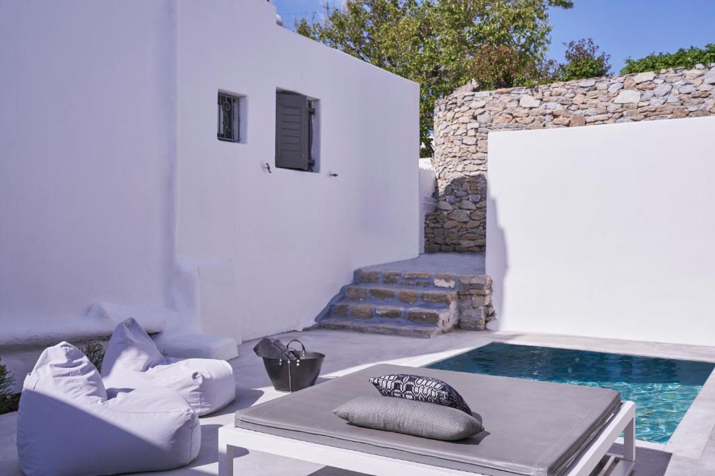 eine Terrasse mit einem Pool mit Kissen und einem Tisch in der Unterkunft Casa Bo Private Pool in Mykonos Stadt