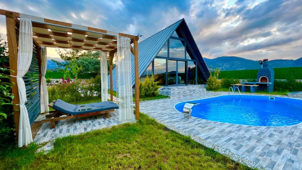 a swimming pool with a pergola next to a house at villa hidden paradise garden in Fethiye