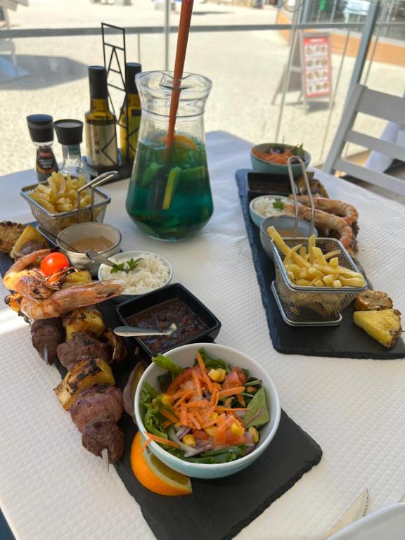 une table avec des assiettes de nourriture sur une table dans l'établissement Alojamento Sudoeste, à Zambujeira do Mar