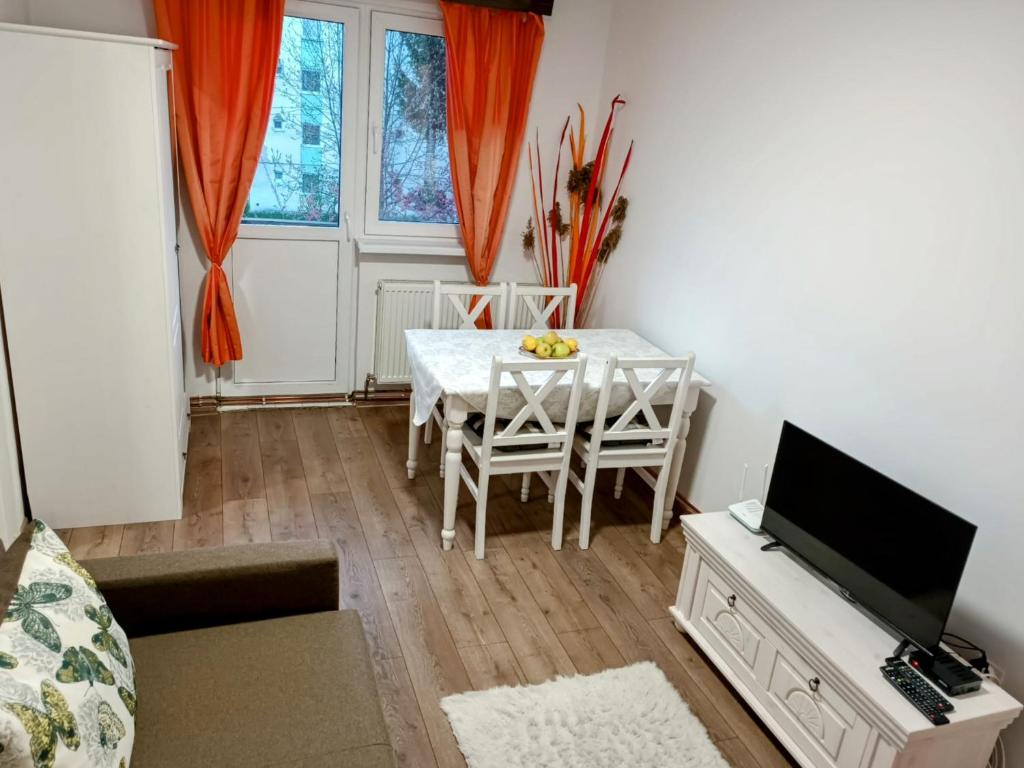 a living room with a table and a television at Lend City Apartment in Miercurea-Ciuc