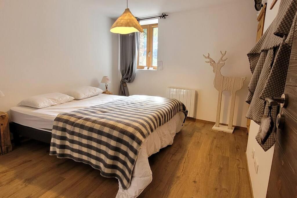 a bedroom with a bed with a checkered blanket on it at Chalet 1829 in Sainte-Foy-Tarentaise