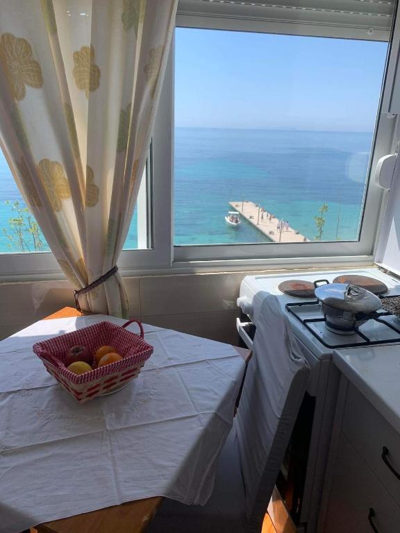 a kitchen with a table with a basket of fruit on it at Sulaj Sea view 2 in Himare