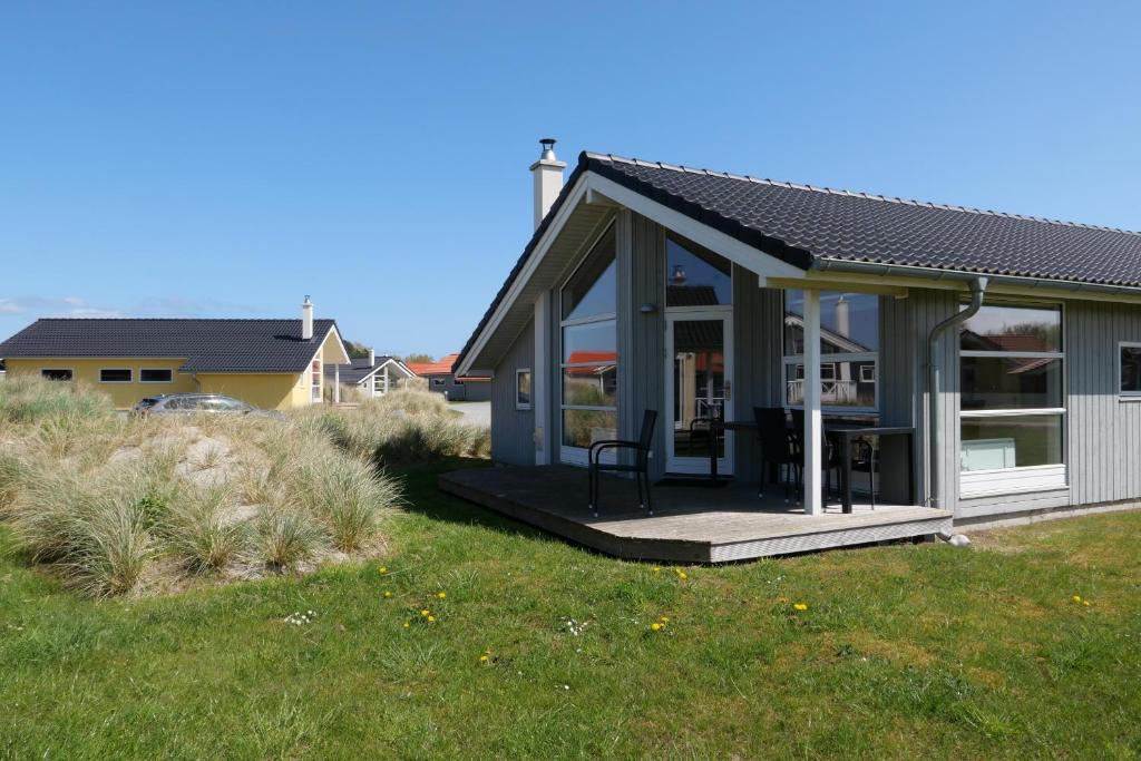 una casa con una veranda riparata su un prato di Resort 2 Beach House B 45 a Grossenbrode