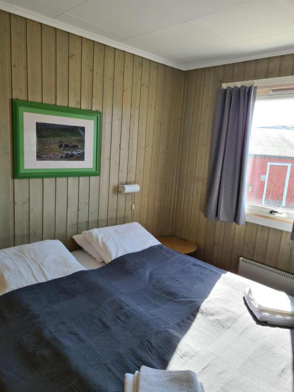 um quarto com uma cama e uma janela em Berlevåg Motell AS em Berlevåg