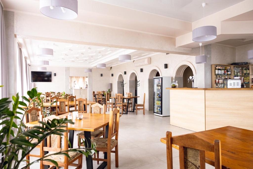 a restaurant with wooden tables and chairs and a counter at Laguna in Luts'k