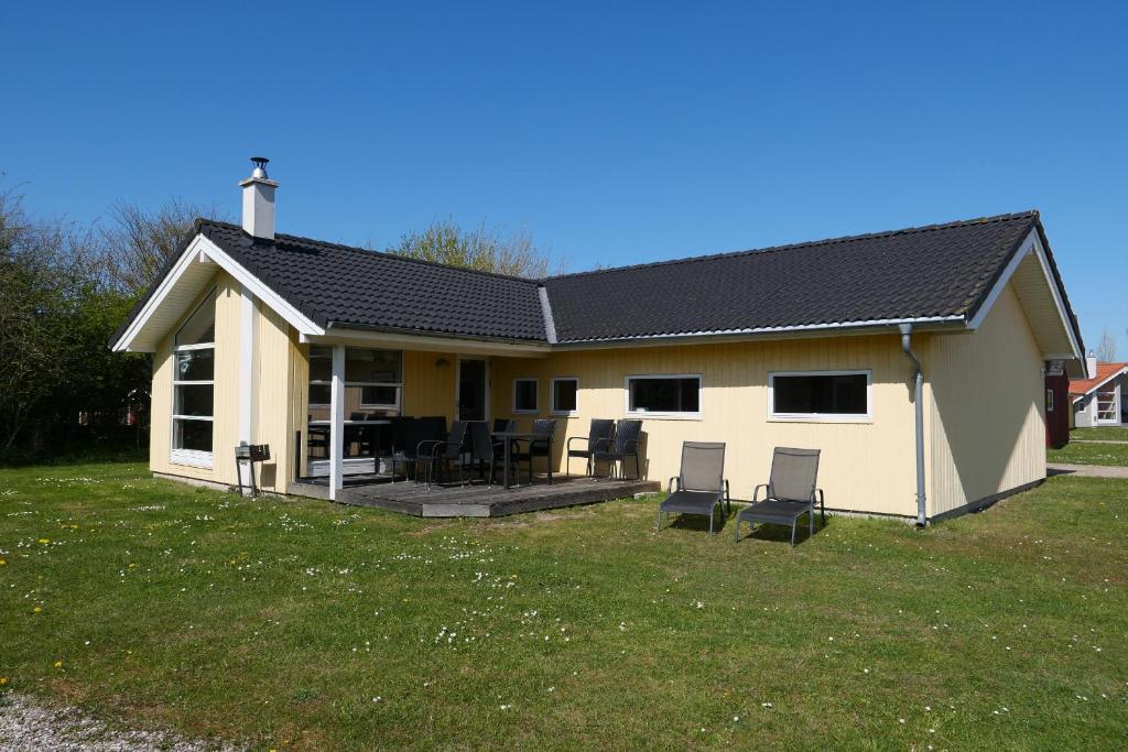 una casa bianca con sedie in cortile di Resort 1 Surfer's Residence E 137 a Grossenbrode