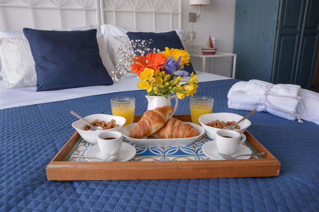 uma bandeja com comida de pequeno-almoço e croissants numa cama em Hotel La Caravella em Agropoli