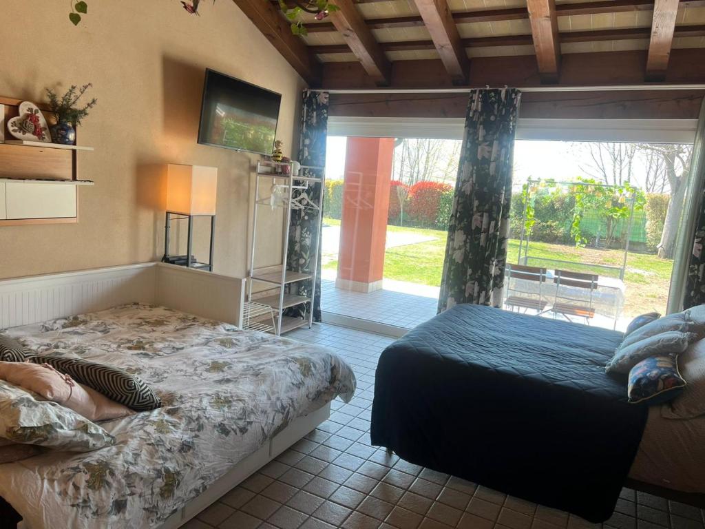 um quarto com 2 camas e uma grande janela em Room in BB - Casa Belvedere - complimentary Wifi and private parking em Veneto