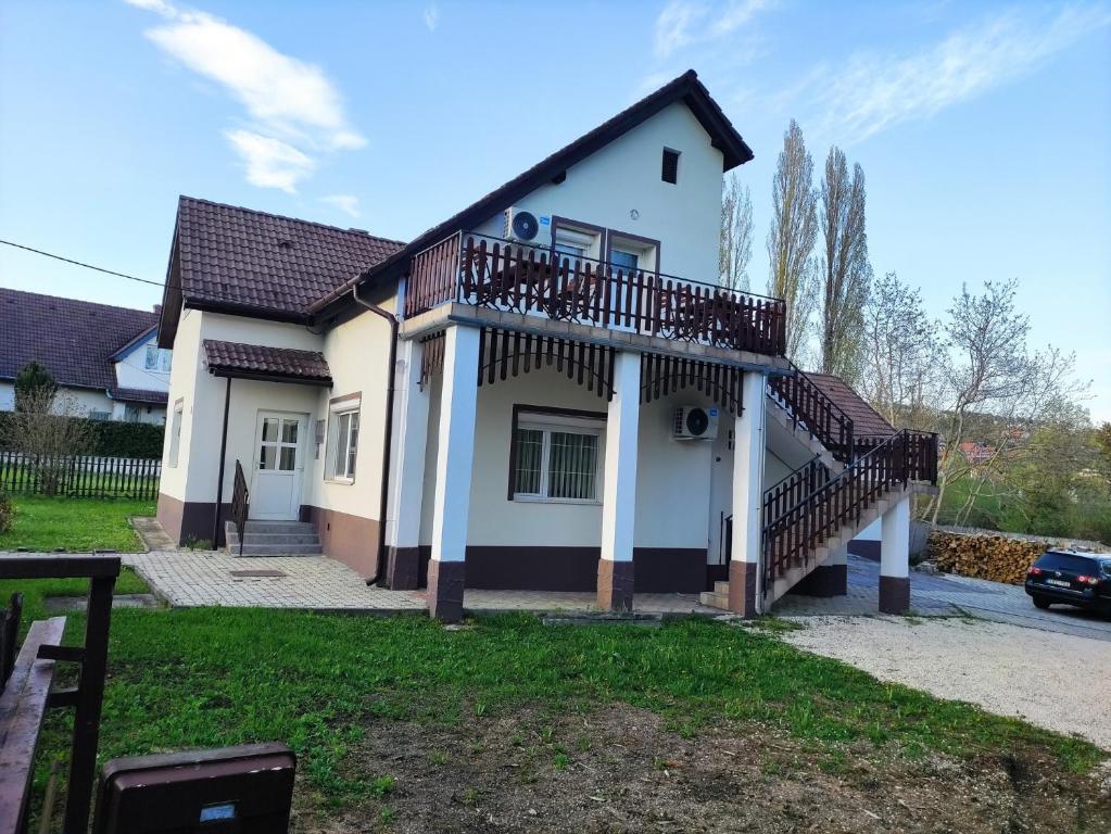 ein Haus mit Balkon darüber in der Unterkunft Gyöngyike Apartmanház Vonyarcvashegy in Vonyarcvashegy