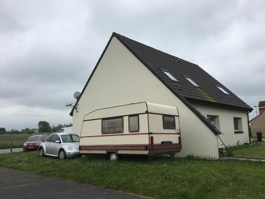 a caravan parked in front of a house at VINTAGE CARAVANE in Les Attaques