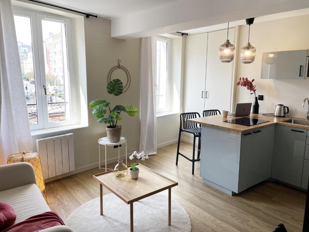 a living room with a kitchen and a table at escapade aux portes de Paris in Suresnes