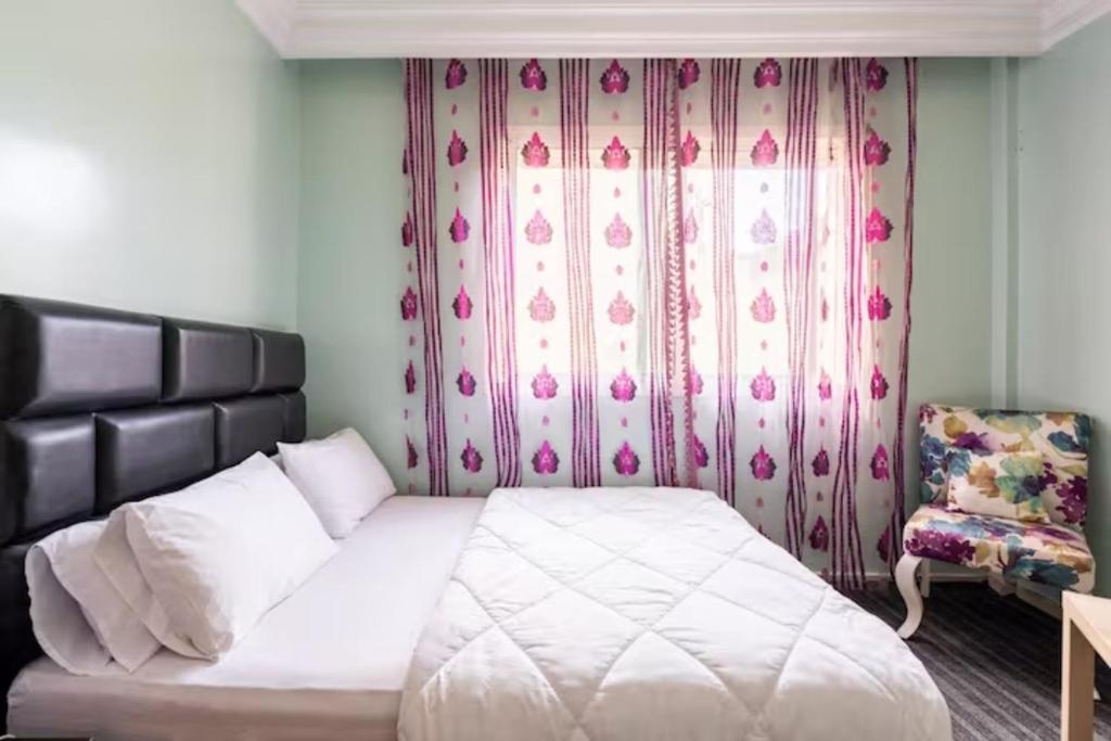 um quarto com uma cama branca e uma cadeira em Homestay, Private room ,Séjours chez l'habitant Casa Voyageurs em Casablanca