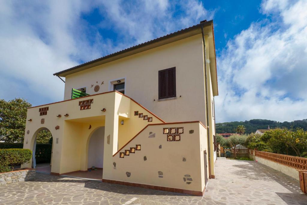 a large building with a staircase in front of it at Aethalia - a 300mt dal mare in Marina di Campo