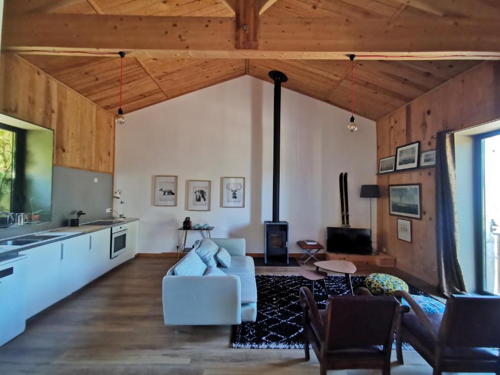 una sala de estar con un sofá blanco y techos de madera. en Gîte de charme au cœur de l'entre-deux-mers en Haux