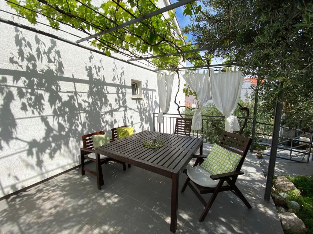 einen Holztisch und Stühle auf einer Terrasse in der Unterkunft Apartement ANCICA in Split