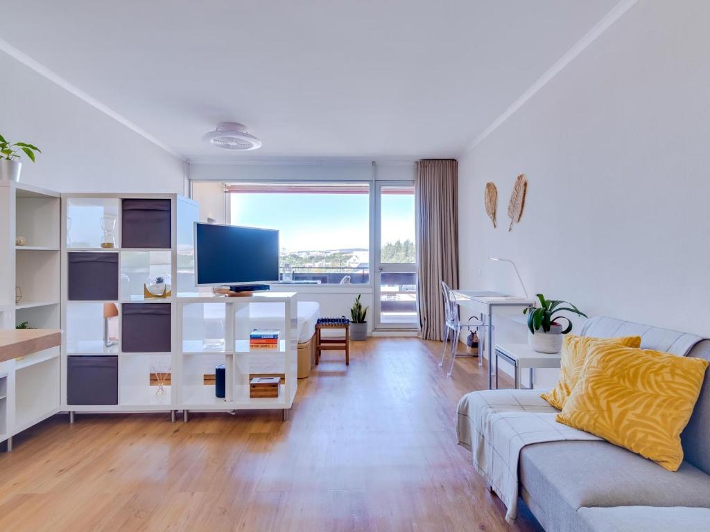 uma sala de estar com um sofá e uma televisão em AL - Be Happy Apartment em Vilamoura
