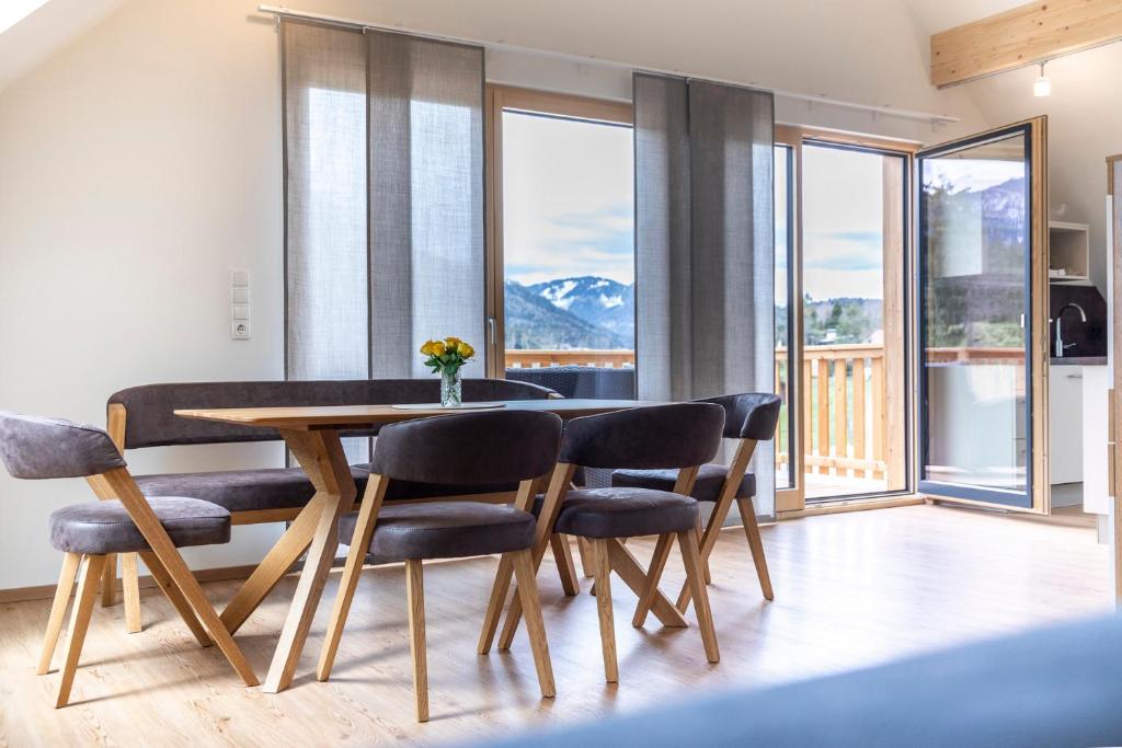 a dining room with a table and chairs and windows at Riesenbauer in Zeutschach