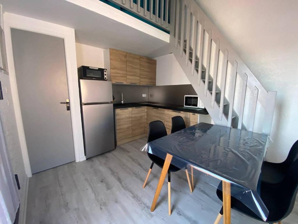 een keuken met een tafel en stoelen en een trap bij Appartement Port Leucate, 2 pièces, 4 personnes - FR-1-81-43 in Port Leucate