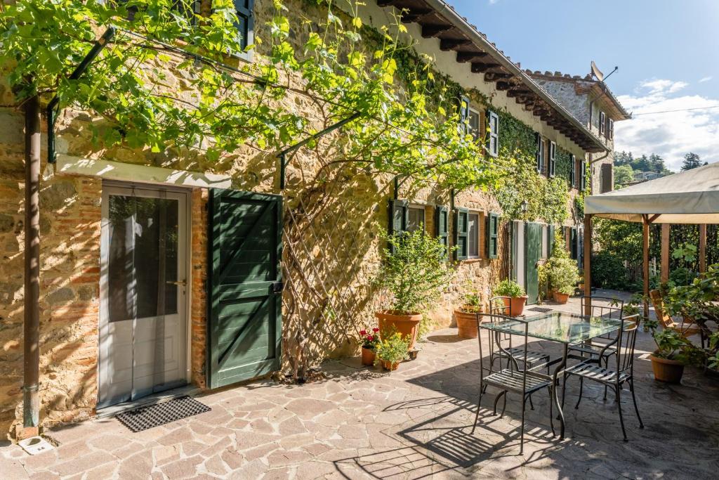 un patio con mesa y sillas junto a un edificio en Abbacca-là appartamento 1, en Lucca