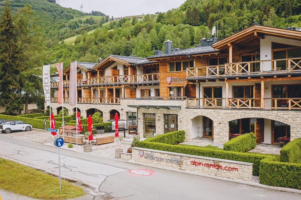 um grande edifício de madeira ao lado de uma rua em AvenidA Mountain Lodges Kaprun em Kaprun