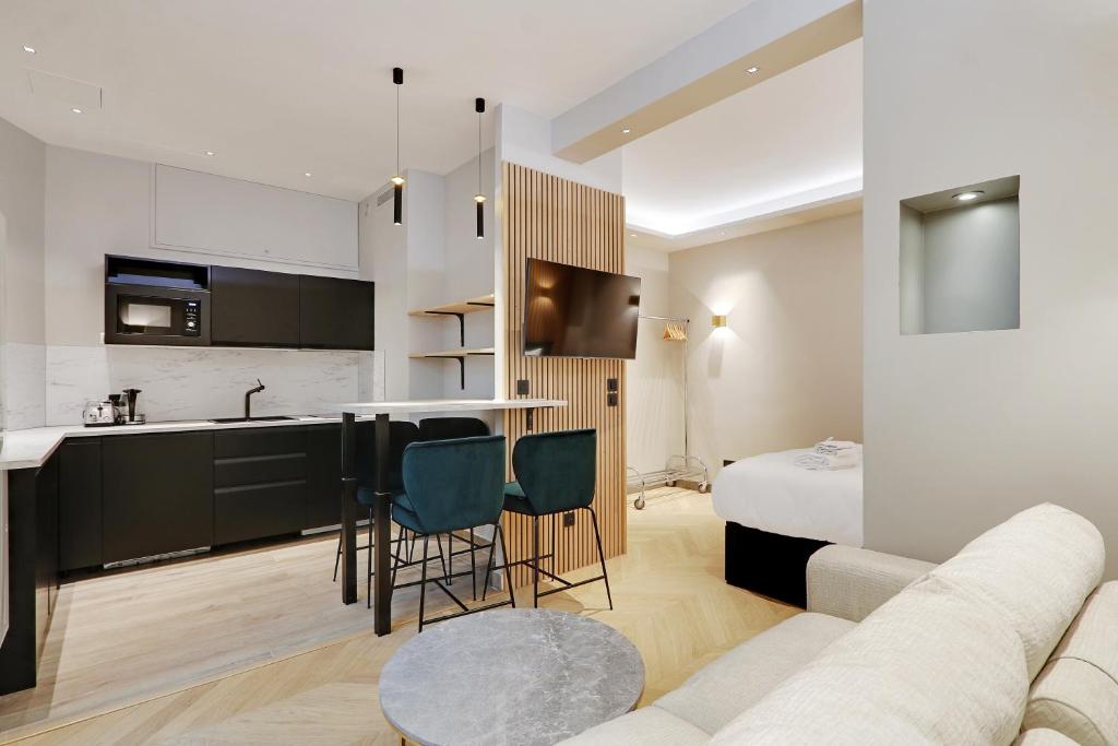 Il comprend une cuisine et un salon avec un canapé et un lit. dans l'établissement Pick A Flat's Apartment in Parc Monceau - Boulevard de Courcelles, à Paris