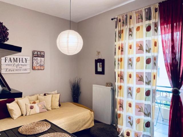 a bedroom with a bed and a window with a curtain at Central Charming Apartment in Tripolis