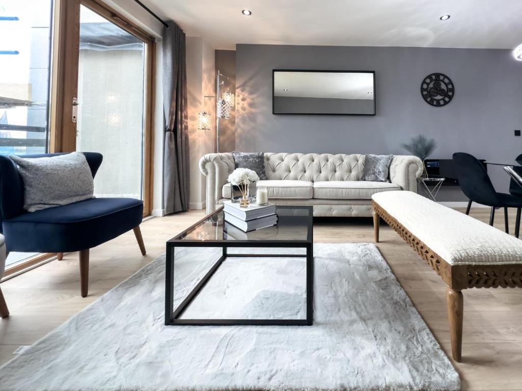 a living room with a couch and a table at Central Leeds Penthouse in Leeds