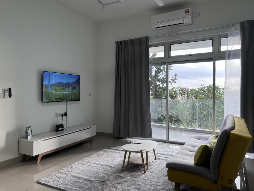 ein Wohnzimmer mit einem Sofa, einem TV und einem Fenster in der Unterkunft Duck Duck House 3BR 7-11 PAX in Johor Bahru