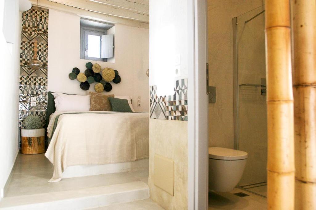 a bedroom with a bed and a toilet in a room at Esperia Luxury Suites in Astypalaia