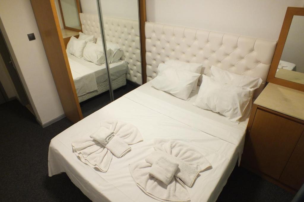 een slaapkamer met een bed met handdoeken erop bij Avalon otel in Kuşadası