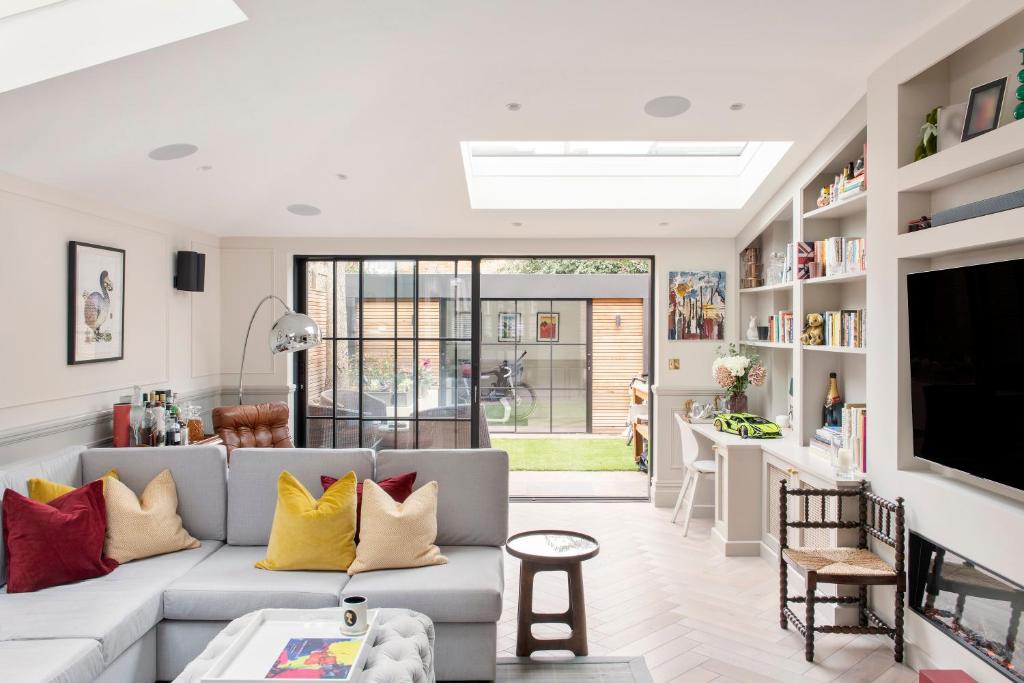 een woonkamer met een bank en een tv bij ALTIDO Spectacular house with private garden in Londen
