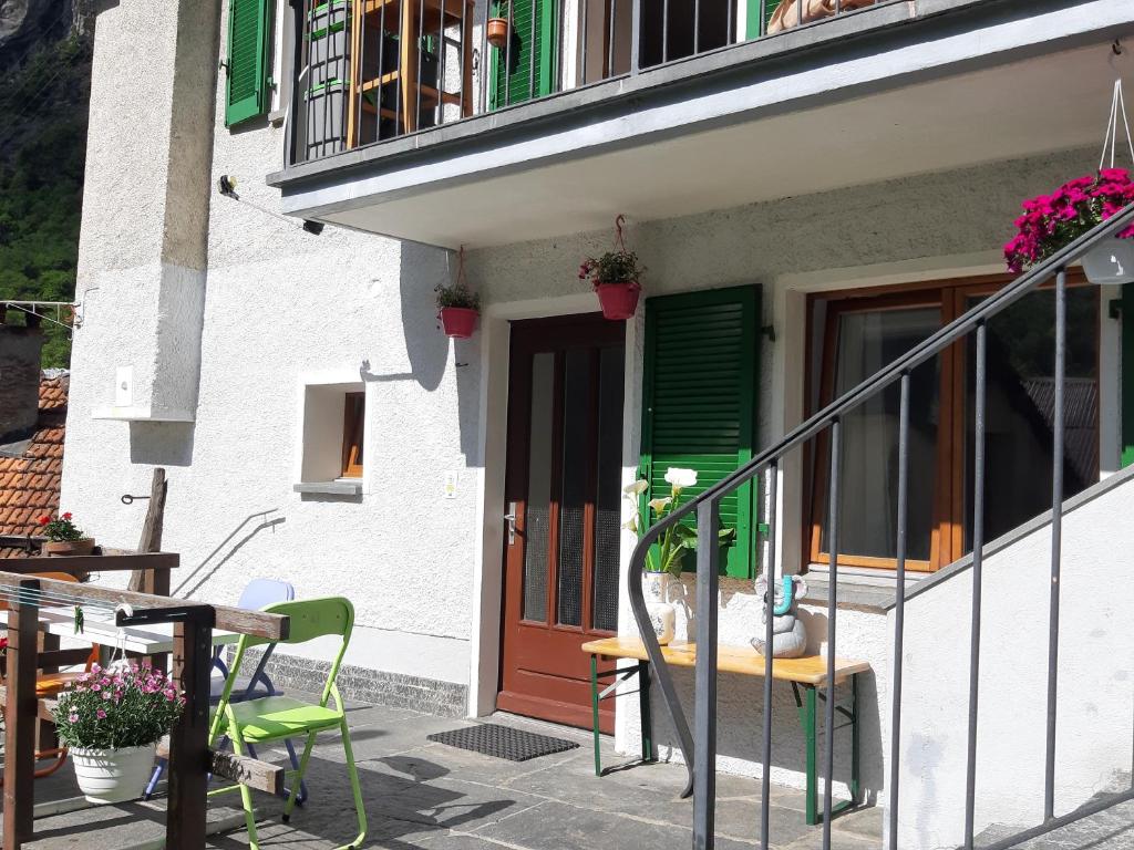 een huis met een deur en een tafel en stoelen bij Casa Allegra- appartamento Calla in Cavergno