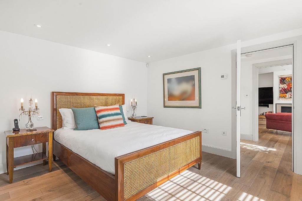 a bedroom with a large bed with a wooden headboard at Veeve - Heart of Hampstead in London