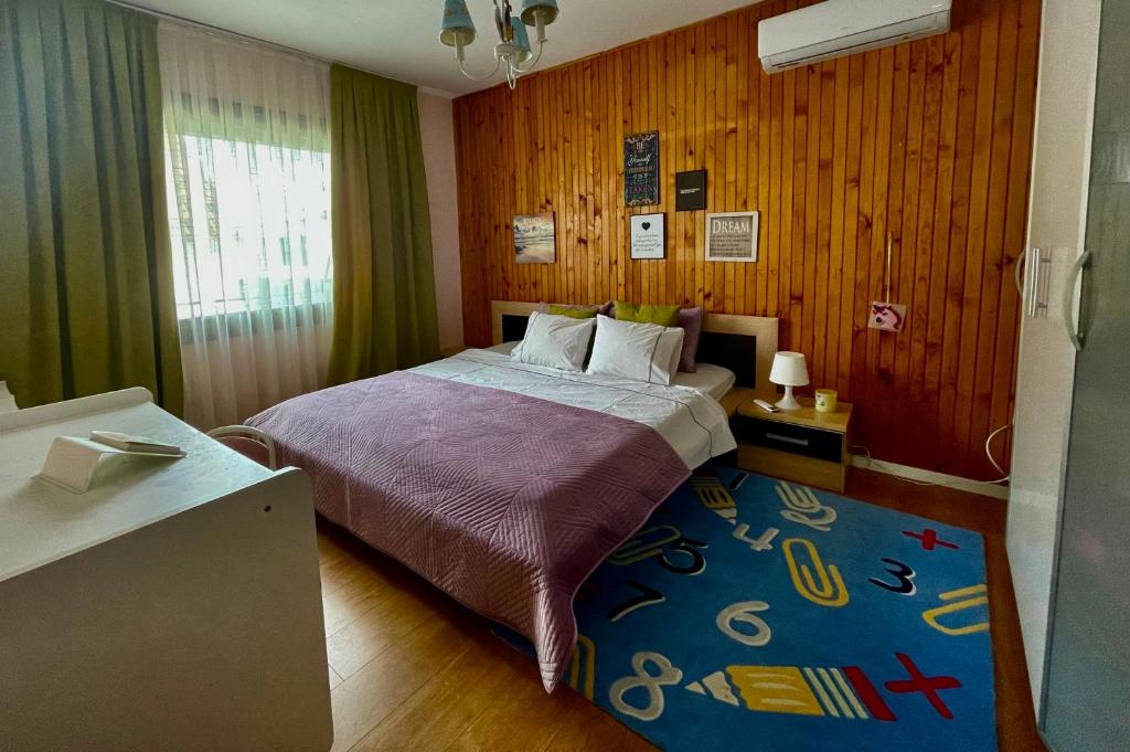 1 dormitorio con 1 cama con alfombra azul en Villa Garden en Pristina