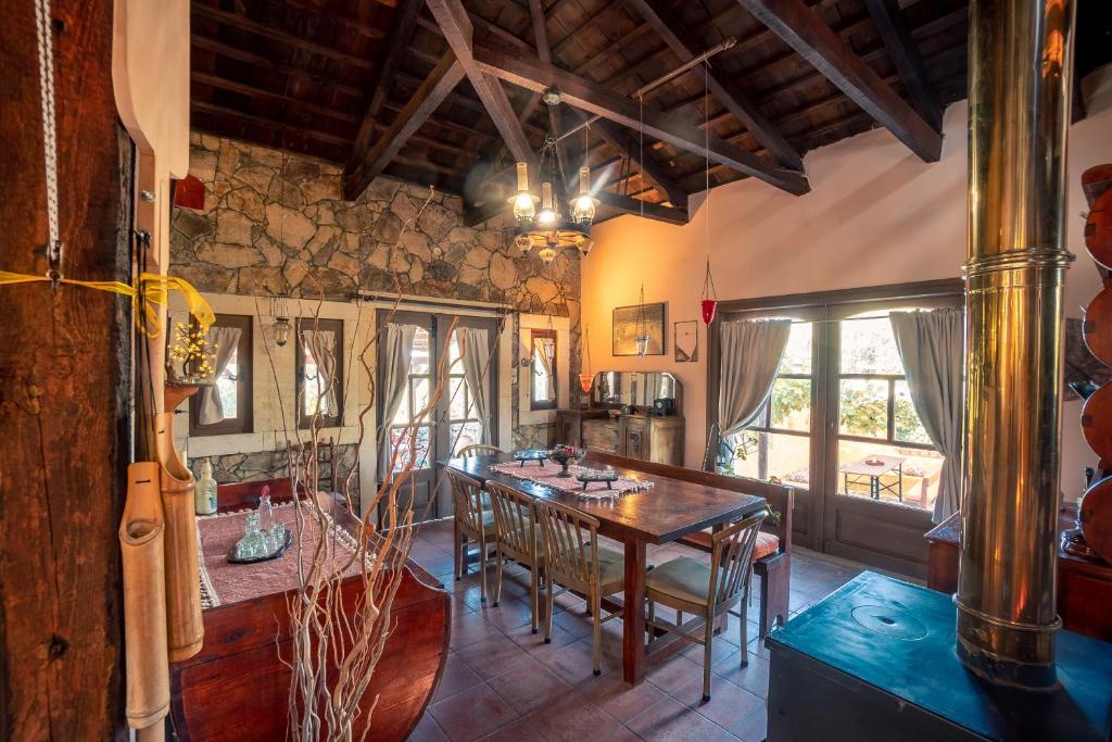 a dining room with a wooden table and chairs at Rustic Retreat in Tílisos