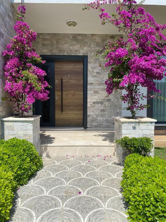 a front door of a house with purple flowers at Villa Kalinda Your Private Sheltered Luxury Villa with Pool Minutes Away from Dalaman Airport in Dalaman