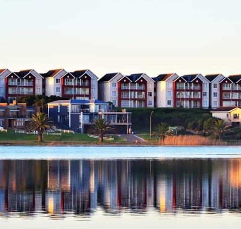 a row of houses next to a body of water at OCEAN VIEW, DOLPHIN BAY 19 ASTON BAY in Jeffreys Bay