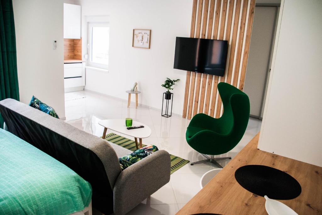 salon z kanapą i zielonym krzesłem w obiekcie Apartments Lisinski - Private parking w Zagrzebiu