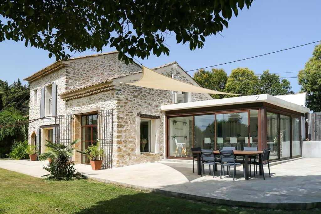 ein Haus mit einem Tisch und Stühlen davor in der Unterkunft Superbe Mas contemporain au pied du Luberon in Cheval-Blanc