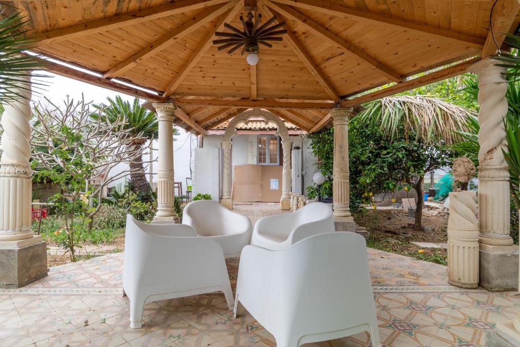 a group of white chairs sitting under a pavilion at Chalet Melody in Santa Croce Camerina