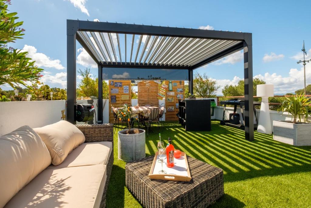 a patio with a couch and a table on the grass at Natura Parc Toit Terrasse in Fréjus
