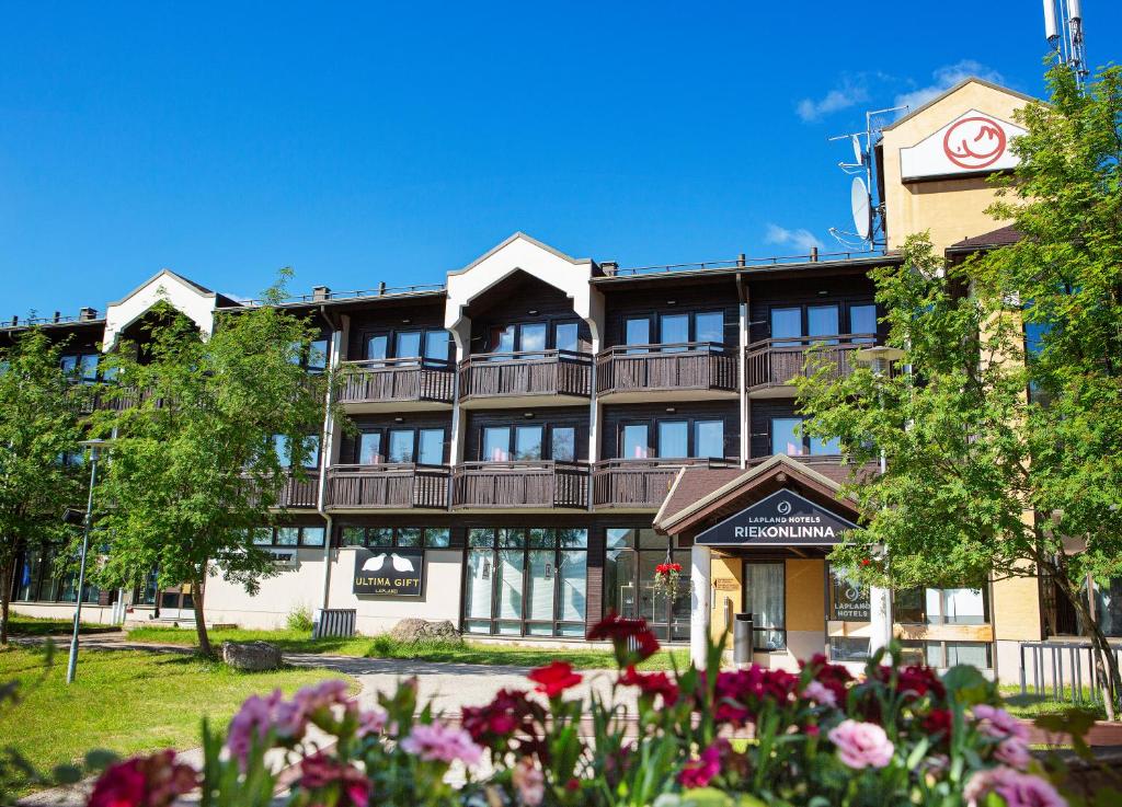 ein großes Gebäude mit Balkonen und Blumen davor in der Unterkunft Lapland Hotels Riekonlinna in Saariselkä