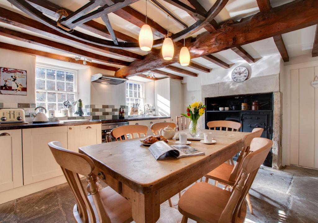 a large kitchen with a wooden table and chairs at Rooks Cottage in Askrigg