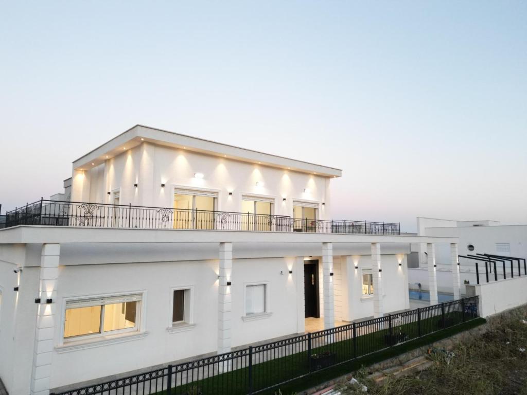 Casa blanca con balcón en la parte superior en הבית הלבן, en Kiryat Shemona