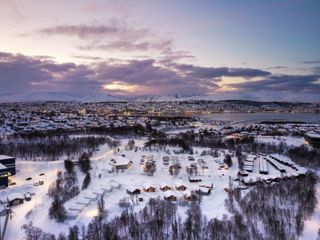 a harbor covered in snow with a city in the background at Tromsø Lodge & Camping in Tromsø