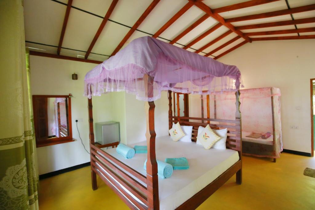 a bedroom with a bed with a canopy at Casa Ninearch Villa in Ella