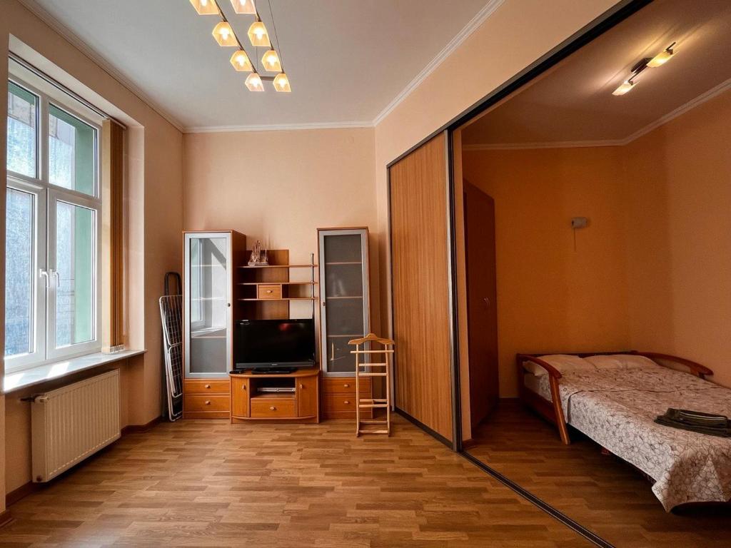 a bedroom with a bed and a flat screen tv at Apartaments near Ploshcha Rynok in Lviv