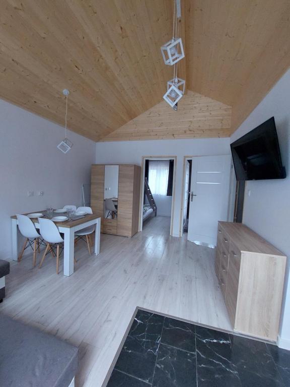 Domki Letniskowe Family Dreams في ساربينوفو: غرفة معيشة مع طاولة وغرفة طعام